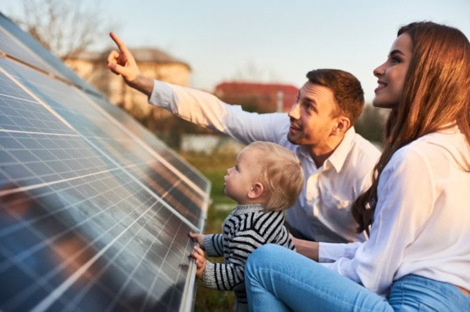 Mann zeigt seiner Familie eine Photovoltaikanlage