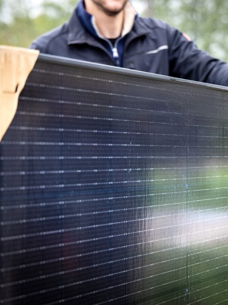 Person mit neuen Solarmodulen zur Installation für Photovoltaikanlage